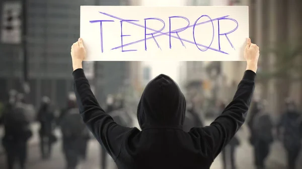 Activista desconocido sostiene un cartel con texto NO TERROR — Foto de Stock