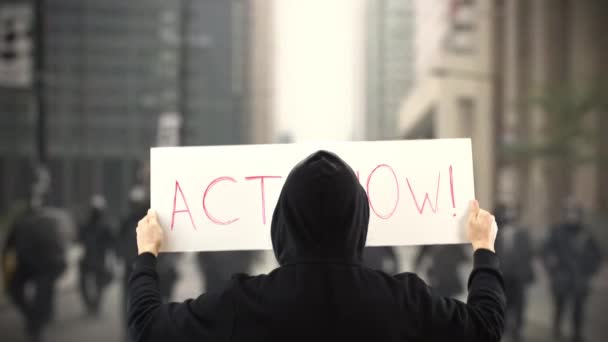 Unbekannter Demonstrant hält Plakat mit ACT NOW-Text in der Hand — Stockvideo