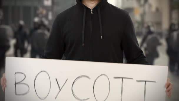 Onbekende relschopper heeft een bordje met tekst van BOYCOTT — Stockvideo
