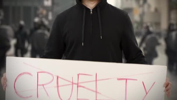 Ακτιβιστής φορώντας μαύρα κρατά μια πινακίδα χωρίς κείμενο CRUELTY — Αρχείο Βίντεο