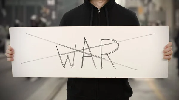 Неизвестный активист держит баннер с надписью "NO WAR" — стоковое фото