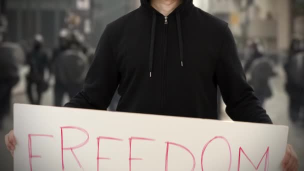 Activista vestido de negro sostiene un cartel con texto de LIBERTAD — Vídeo de stock