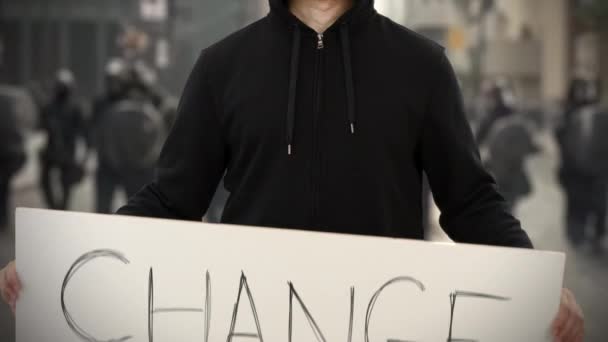 Ακτιβιστής φορώντας μαύρα κρατά μια πινακίδα με κείμενο ΑΛΛΑΓΩΝ — Αρχείο Βίντεο