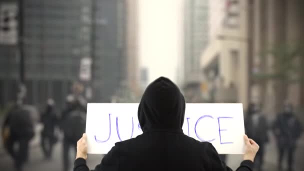 Okänd protestant håller ett plakat med JUSTICE text — Stockvideo