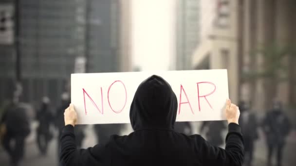 Un manifestant inconnu tient une pancarte sans texte de la GUERRE — Video
