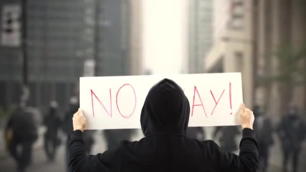 不知名的抗议者拿着一个标语牌，上面没有文字 — 图库视频影像