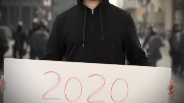 Activista desconocido sostiene un cartel con texto de 2020 — Vídeo de stock