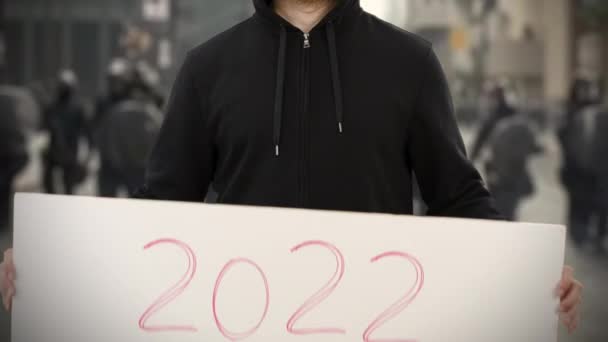 Activista desconocido sostiene un cartel con texto de 2022 — Vídeo de stock