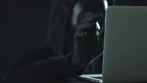 El hacker con máscara negra saca la pestaña VIRUS de un portátil. Concepto de hackeo — Vídeo de stock