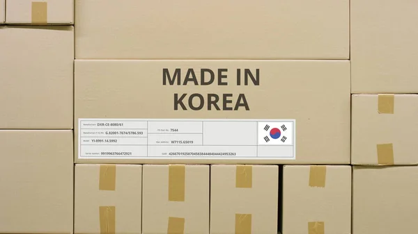 MADE IN KOREA texto e etiqueta da bandeira na embalagem num armazém — Fotografia de Stock