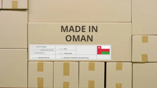 Caja con texto impreso MADE IN OMAN y pegatina de la bandera en un almacén —  Fotos de Stock