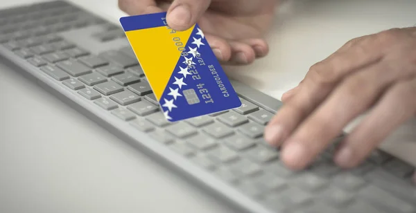 Homme paie en ligne avec une carte bancaire avec le drapeau imprimé de Bosnie-Herzégovine. Numéros fictifs — Photo