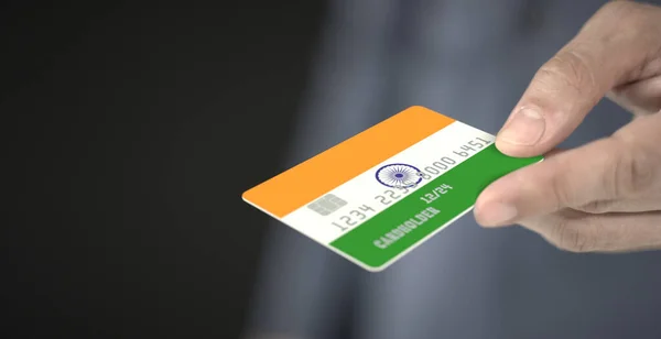 Man gives plastic bank card with printed flag of India. Fictional numbers — Stock Photo, Image