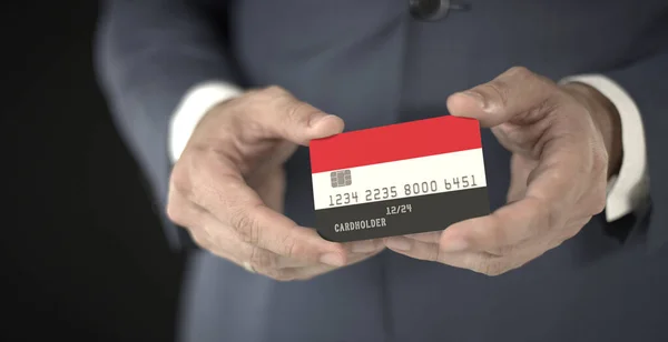 Επιχειρηματίας κατέχει πλαστική τραπεζική κάρτα με τυπωμένη σημαία της Υεμένης στα χέρια του, φανταστικούς αριθμούς — Φωτογραφία Αρχείου