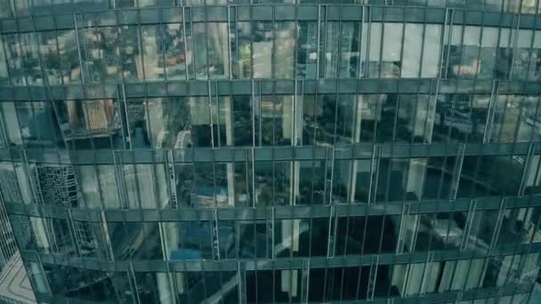 Aerial view of panoramic windows of a skyscraper reflecting big city — Stock Video