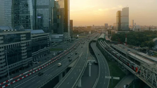Luftaufnahme einer wichtigen Stadtautobahn und eines Eisenbahnzuges an Wolkenkratzern im Geschäftsviertel am frühen Morgen — Stockfoto