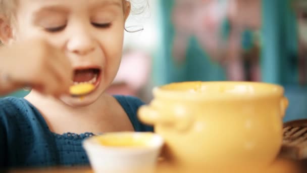 Loira bebê menina comer sopa de abóbora — Vídeo de Stock