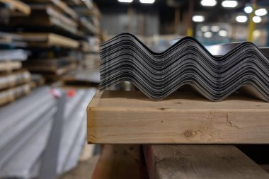 Müşterilere teslim etmek için ahşap paletin üzerinde bir yığın çatılı çarşaf.