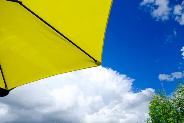 Amarelo deck pátio guarda-chuva fora sob céus ensolarados — Fotografia de Stock