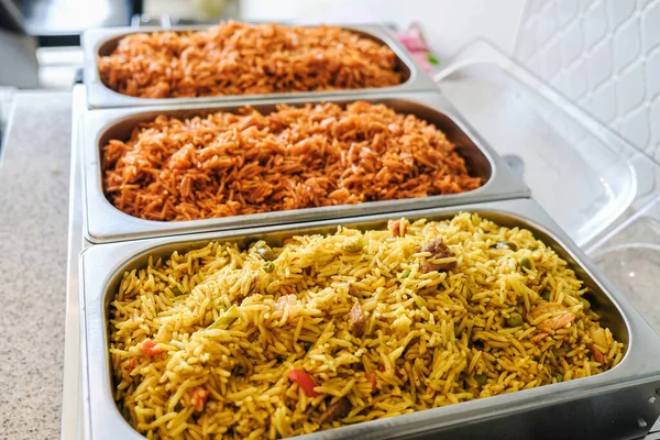 Jollof nigerian și orez prăjit de legume servit în farfurie Chaffing — Fotografie, imagine de stoc