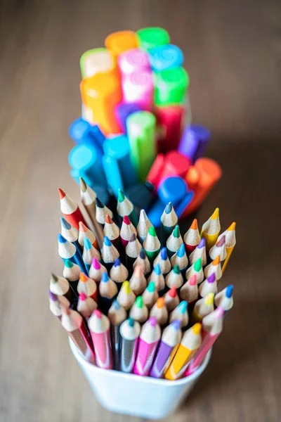 Verzameling van gekleurde potloden, pennen en hoogliggers in penhouders — Stockfoto