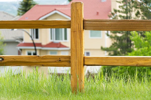 Wood fence in a park with a house behind