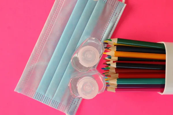 Hand Sanitizer, face masks and colored pencils to go back to school — Stock Photo, Image