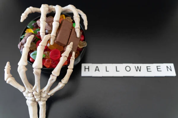 Ciotola di Halloween Candy coperto con artigli scheletro - Concetto di Halloween — Foto Stock