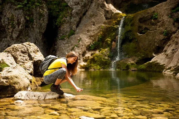 Aktivní Mladá Žena Pitnou Vodu Horské Bystřiny Teplý Jarní Den — Stock fotografie