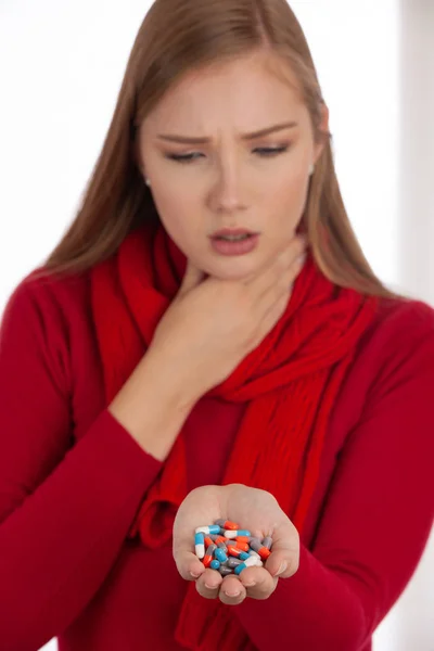 Wanita Muda Bersweater Merah Memegang Pil Tangannya Saat Dia Sakit — Stok Foto