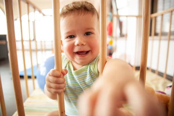 Niedliches Lächelndes Baby Das Durch Die Holzstäbe Seiner Krippe Oder — Stockfoto