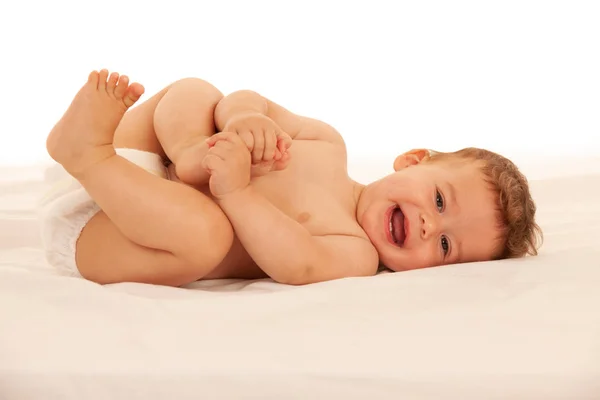 Rapaz Feliz Fralda Brincando Cama Isolado Sobre Branco — Fotografia de Stock