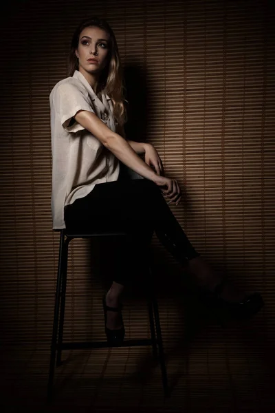 Fashionable Young Woman Sits Chair Wit Wooden Wall Background — Stock Photo, Image