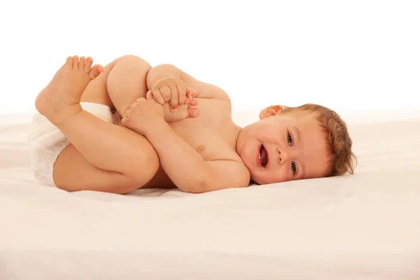 Hapy baby boy in playing on bed isolated over white — Stock Photo, Image