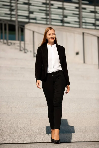 Giovane donna d'affari camminare sulle scale lasciando edificio per uffici — Foto Stock