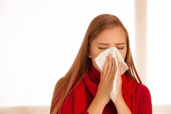 Mujer estornuda sosteniendo un pañuelo nasal —  Fotos de Stock
