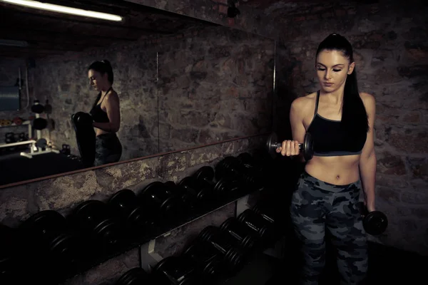 Hermosa joven mujer caucásica con entrenamiento de pelo negro en fitne — Foto de Stock