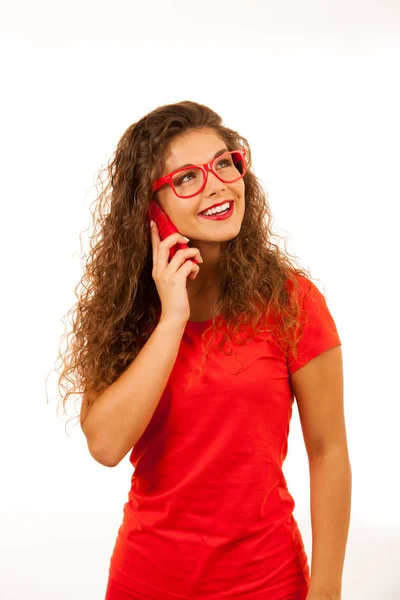 Красива молода жінка в червоному розмовляє на смартфоні ізольовано — стокове фото