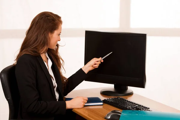 Mulher de negócios jovem e solteira trabalhando em sua mesa no escritório — Fotografia de Stock