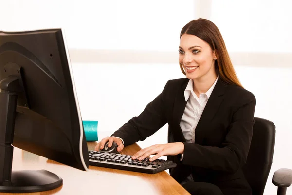 Attractive young business woman works at her desk in the office — Stock Photo, Image