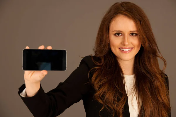 Attraente donna d'affari detiene un tablet o smartphone wtih blan — Foto Stock