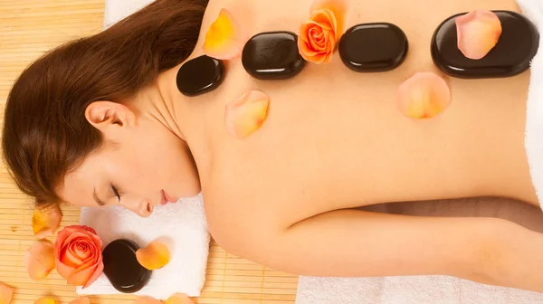 Terapia de piedra. Mujer recibiendo un masaje de piedra caliente en el salón de spa —  Fotos de Stock