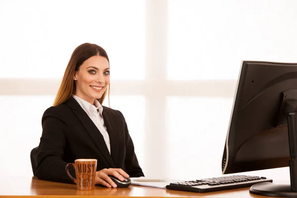 Attraente giovane donna d'affari lavora alla sua scrivania in ufficio — Foto Stock