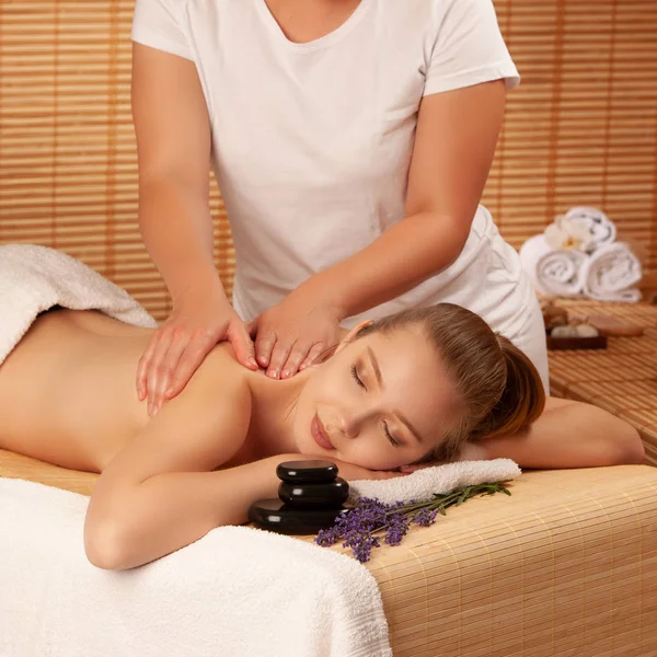 Schöne junge Frau mit einer Massage-Behandlung im Wellness-Salon - — Stockfoto