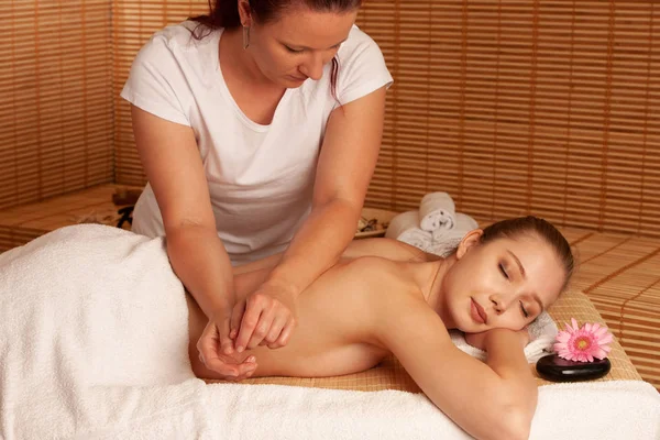 Schöne junge Frau mit einer Massage-Behandlung im Wellness-Salon - — Stockfoto