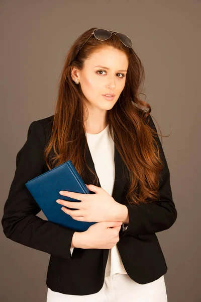Привлекательная деловая женщина с ноутбуком на сером фоне — стоковое фото