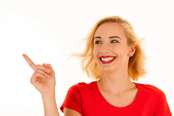 Attractive beautiful young blonde woman pointing into copyspace — Stock Photo, Image