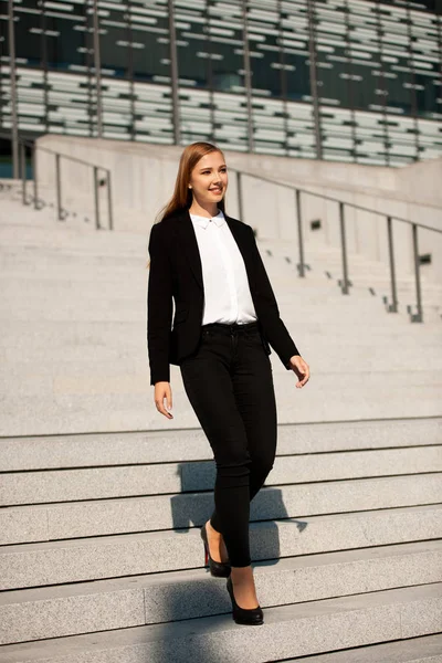 Young business woman walk on stairs leaving office building — Stock Photo, Image