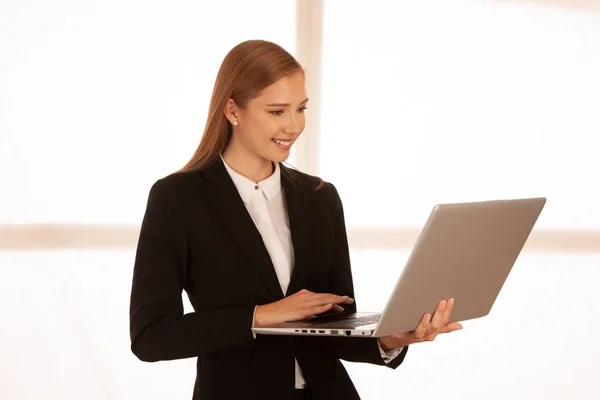在笔记本电脑上工作的年轻商业妇女的企业肖像 — 图库照片