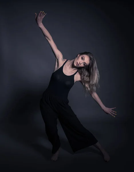 Mooie danser-jonge vrouw dansen over donkergrijze achtergrond — Stockfoto